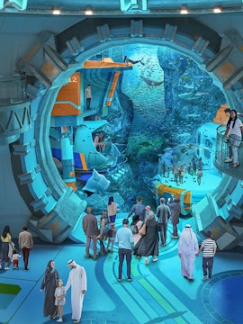 Visitors exploring an underwater-themed attraction with large aquarium and marine life.