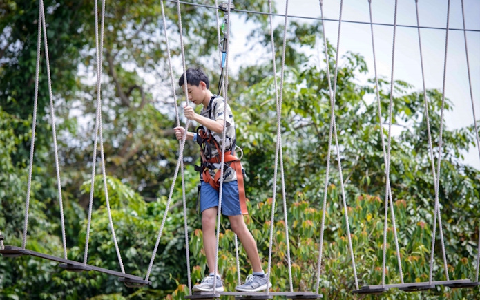 Person navigating a rope course at Mega Adventure Park, Singapore.