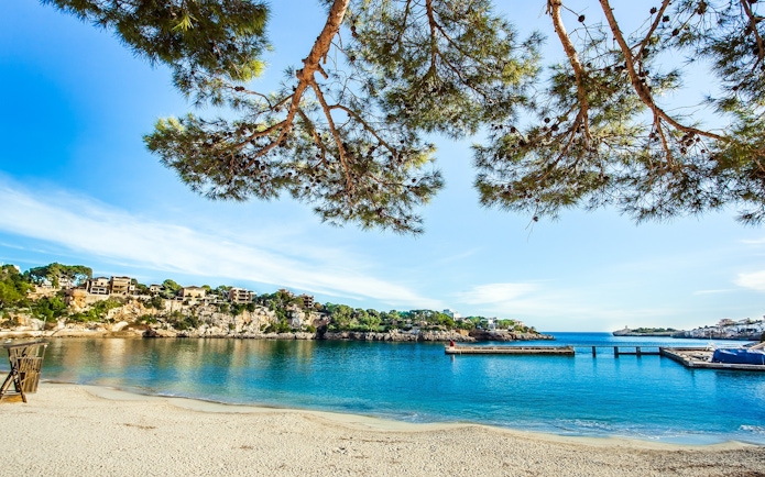 Porto Cristo beach with clear water and rocky cliffs, Mallorca, Spain.
