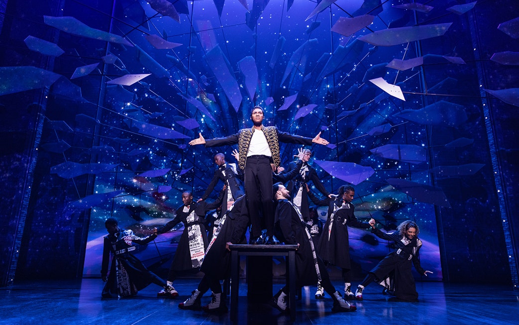 Performer on stage with dancers at MJ Live Tribute Concert.