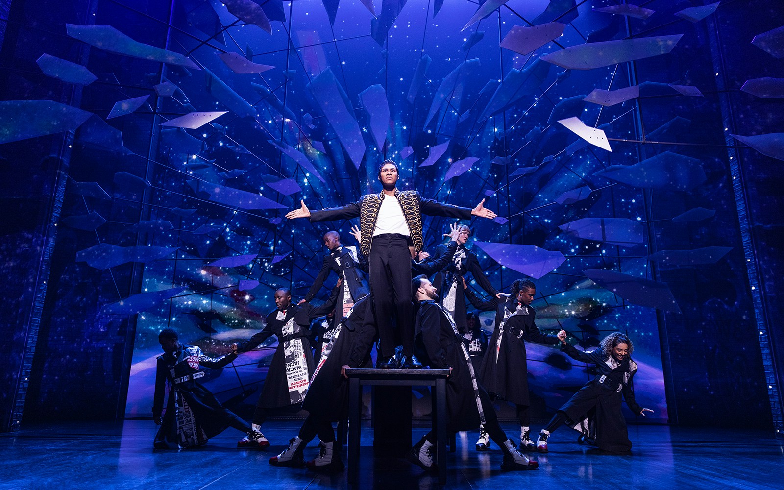 Performer on stage with dancers at MJ Live Tribute Concert.
