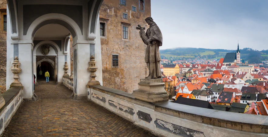 Cesky Krumlov Castle bridge view with historic architecture and lush greenery in the Czech Republic.
