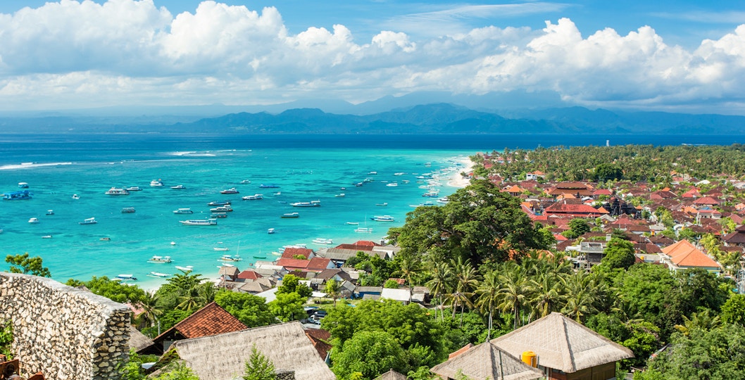 Nusa Lembongan coastline with boats in turquoise water, view from above, Indonesia.