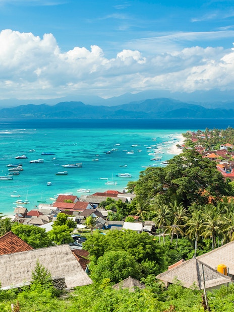 Nusa Lembongan coastline with boats in turquoise water, view from above, Indonesia.