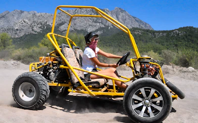 Buggy driving on a dirt trail with mountains in the background during Alanya Buggy Safari tour.