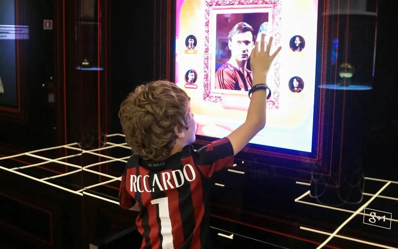 Child interacting with digital display at Casa Milan Museum, Italy.