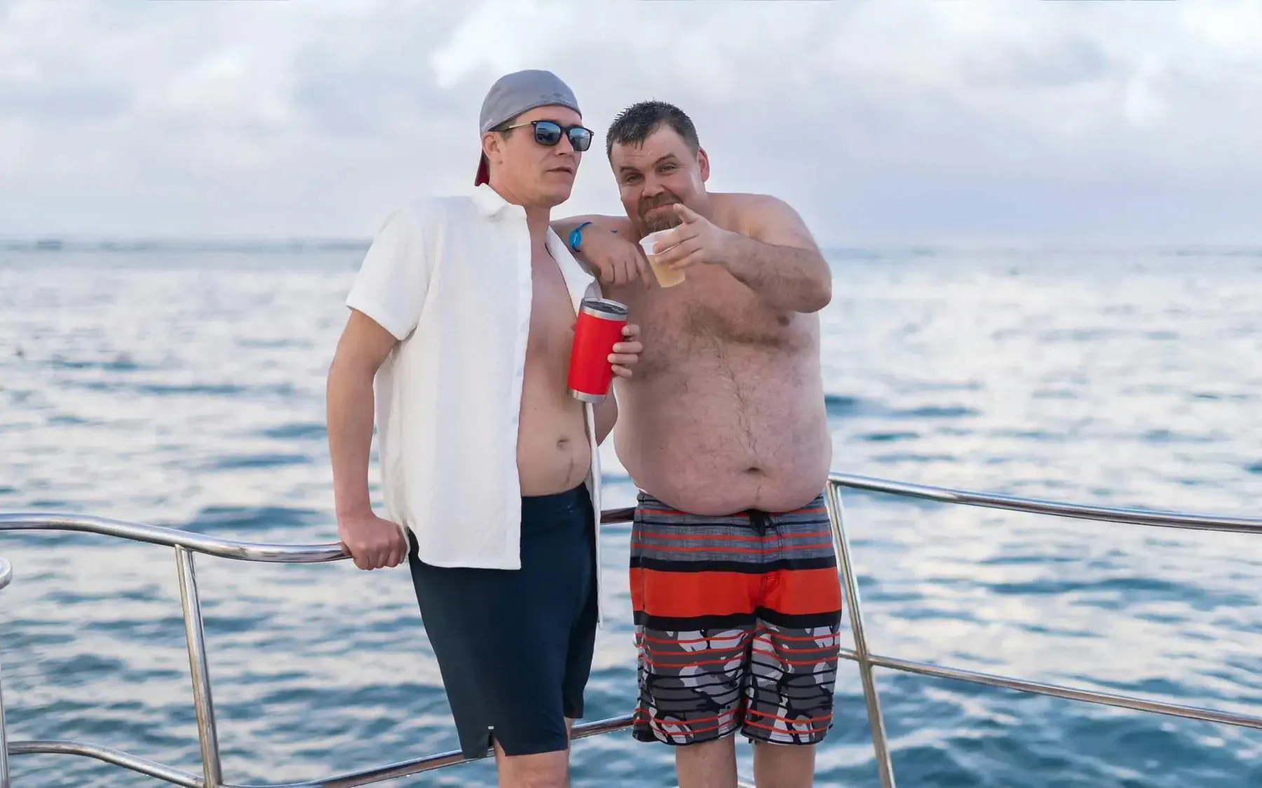 Men enjoying drinks on a boat during a Punta Cana snorkeling tour in the Caribbean Sea.