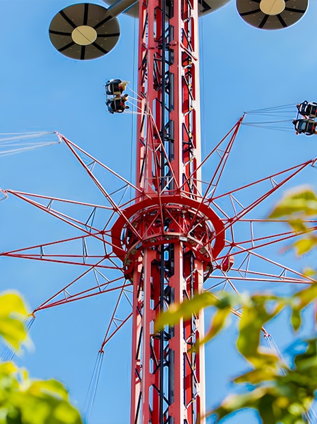 Star Flyer ride at Parque de Atracciones de Madrid with people swinging high in the air.