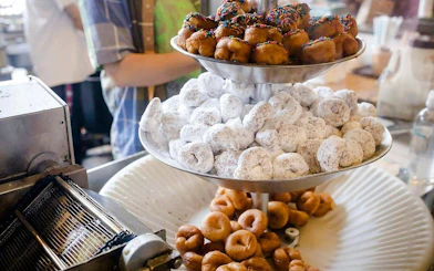 Assorted donuts on a tiered tray at a morning market during a Coffee Crawl VIP experience.
