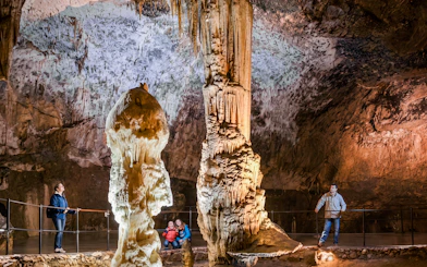Visitors exploring stalagmites in Postojna Cave, Slovenia.