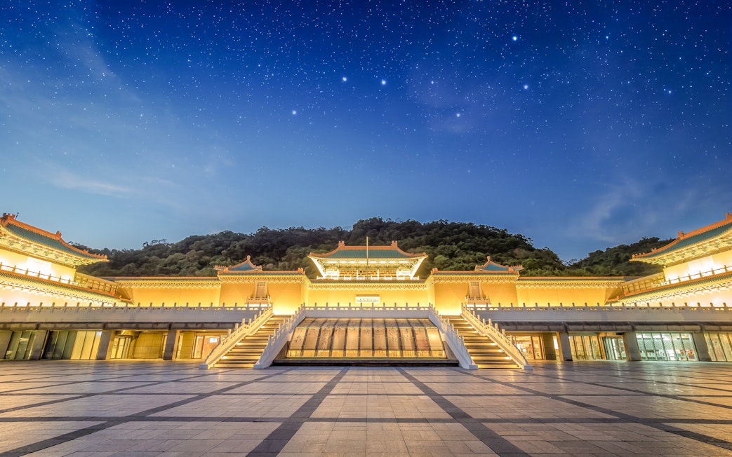 Taiwan Palace Museum illuminated at night with starry sky backdrop.