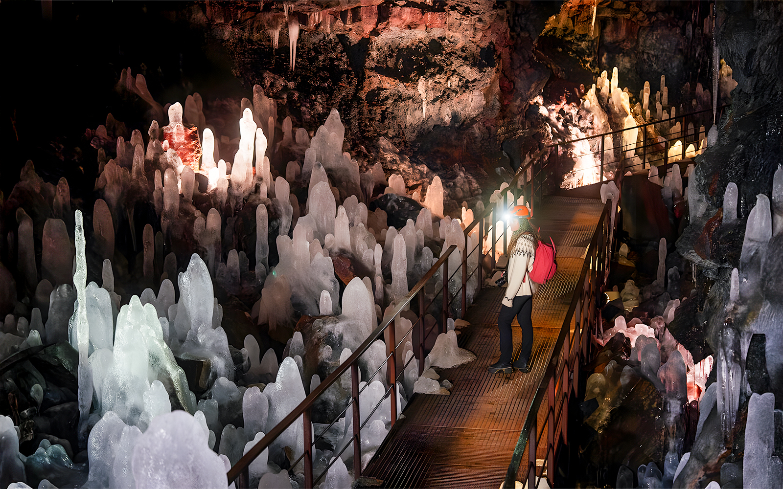 Guest exploring volcanic crystals in Raufarhólshellir Lava Cave, Iceland.