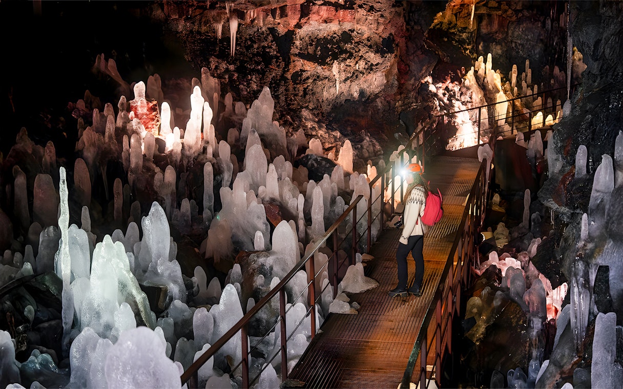 Guest exploring volcanic crystals in Raufarhólshellir Lava Cave, Iceland.