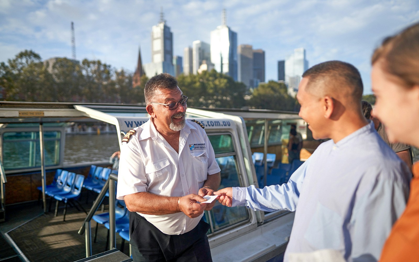People boarding the Melbourne City and Williamstown Ferry Cruise with city skyline in background.