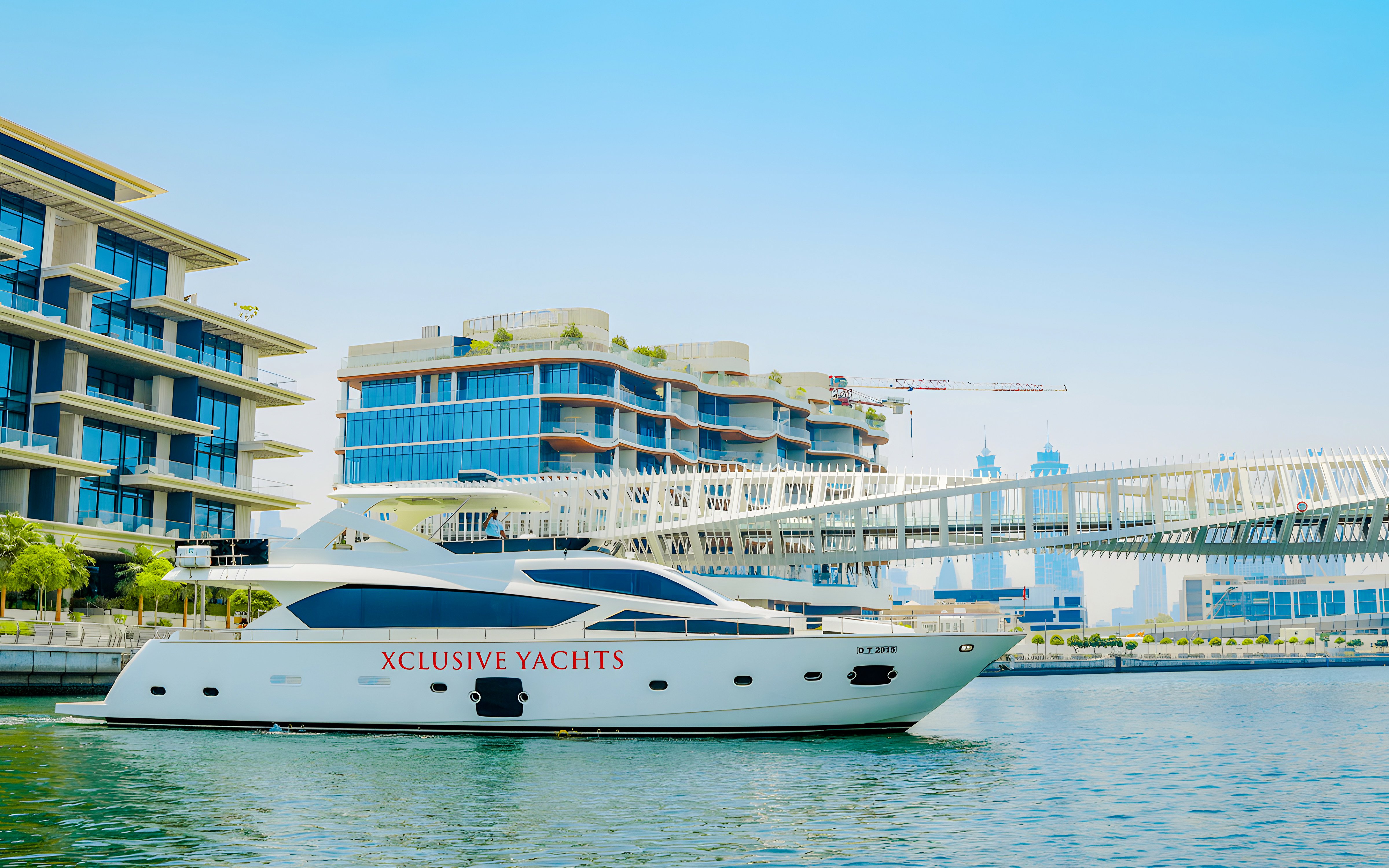 Yacht cruising through Dubai canal with skyline and Burj Khalifa in the background.