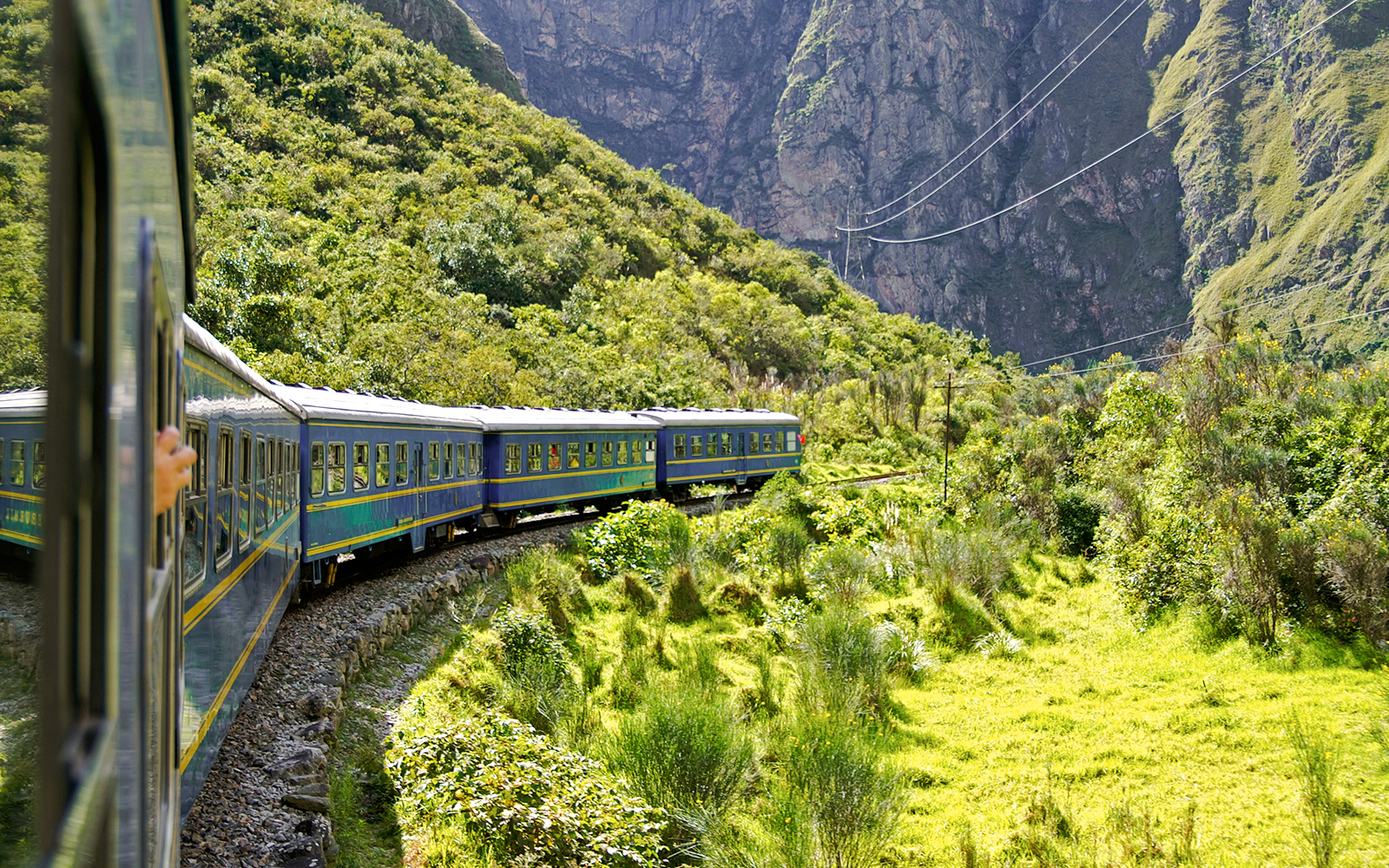 Train winding through lush mountains en route to Machu Picchu, Peru.