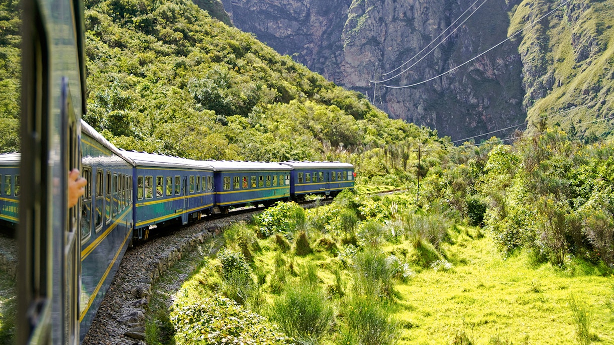 Train winding through lush mountains en route to Machu Picchu, Peru.