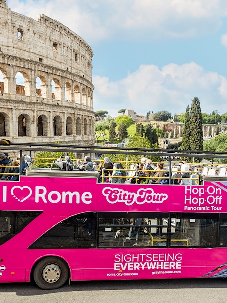 Open-top tour bus in front of the Colosseum, part of the I Love Rome Hop-On Hop-Off Tour.