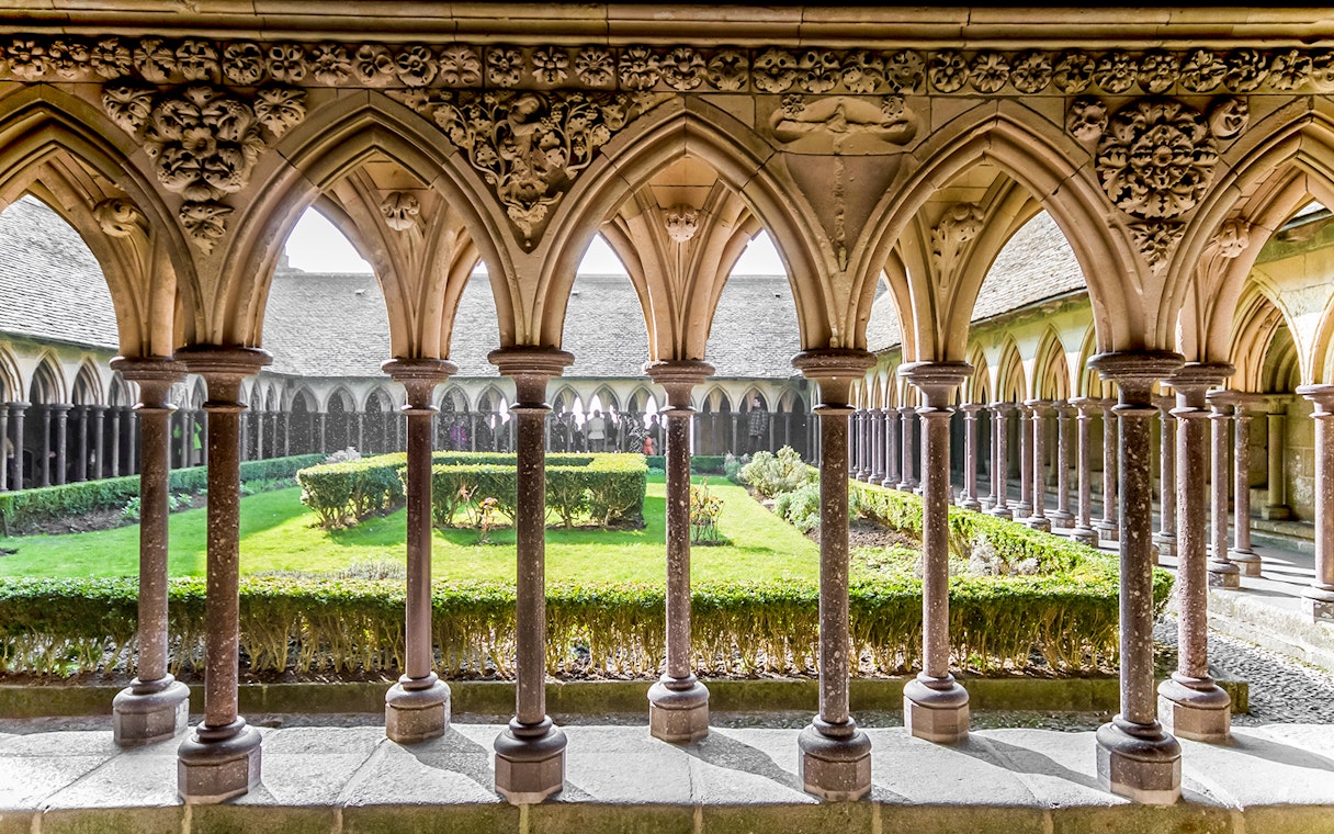 Cloister arches and garden at Mont St. Michel Abbey, France.