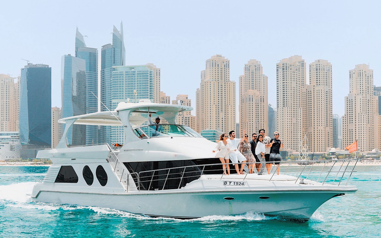Bluewater yacht cruising with Dubai Marina skyline in the background.