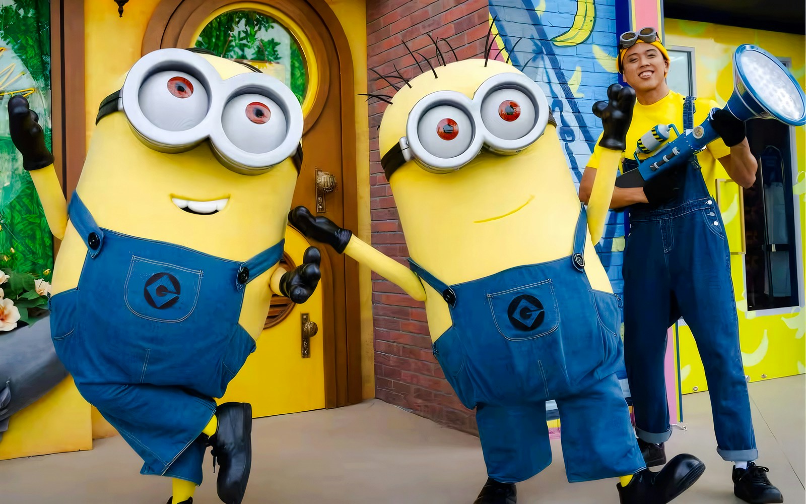 Minions dancing with a performer in the vibrant Minion Marketplace.