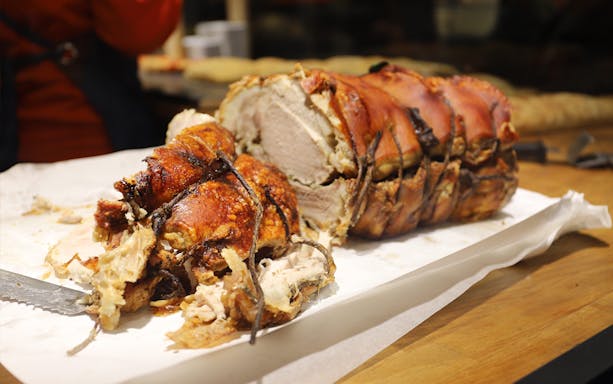 Porchetta on a cutting board during a morning food tour in Rome.
