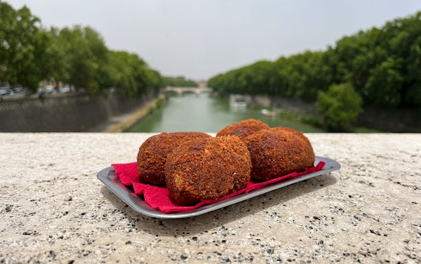 Roman arancini on a tray by the Tiber River, Rome.