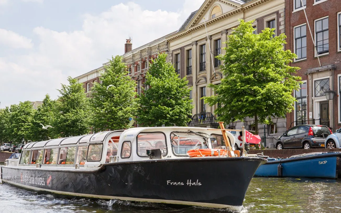Haarlem canal cruise boat passing historical buildings.