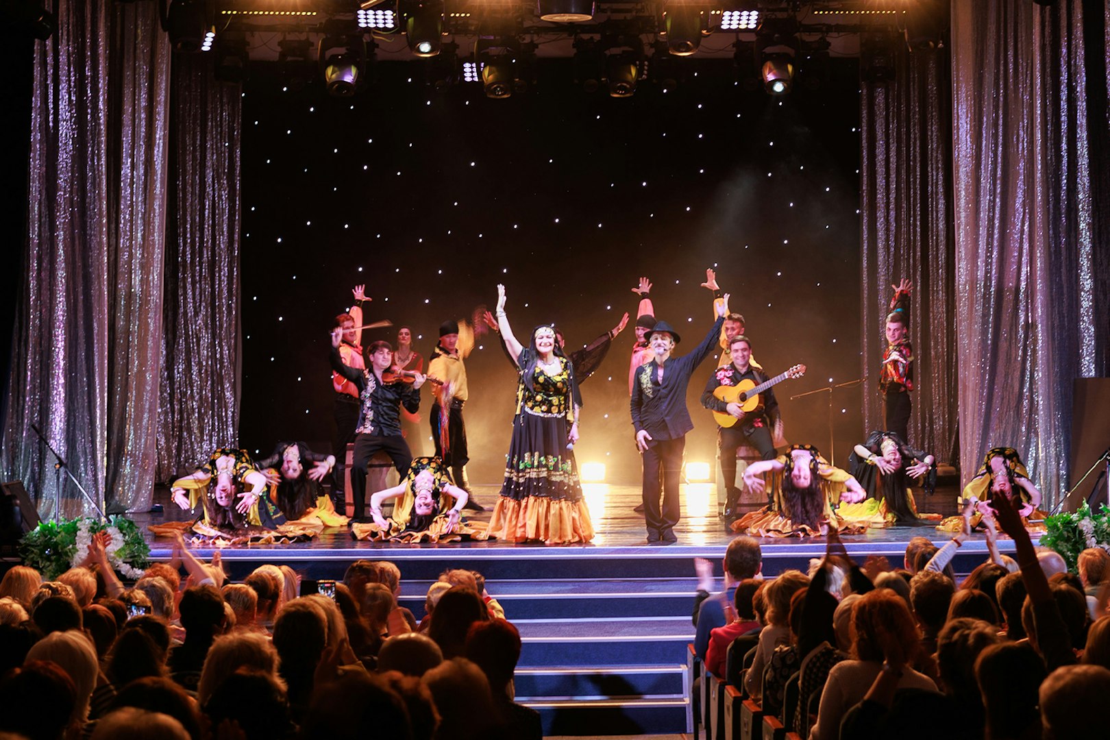 Flamenco dancers performing on stage in Granada with audience watching.