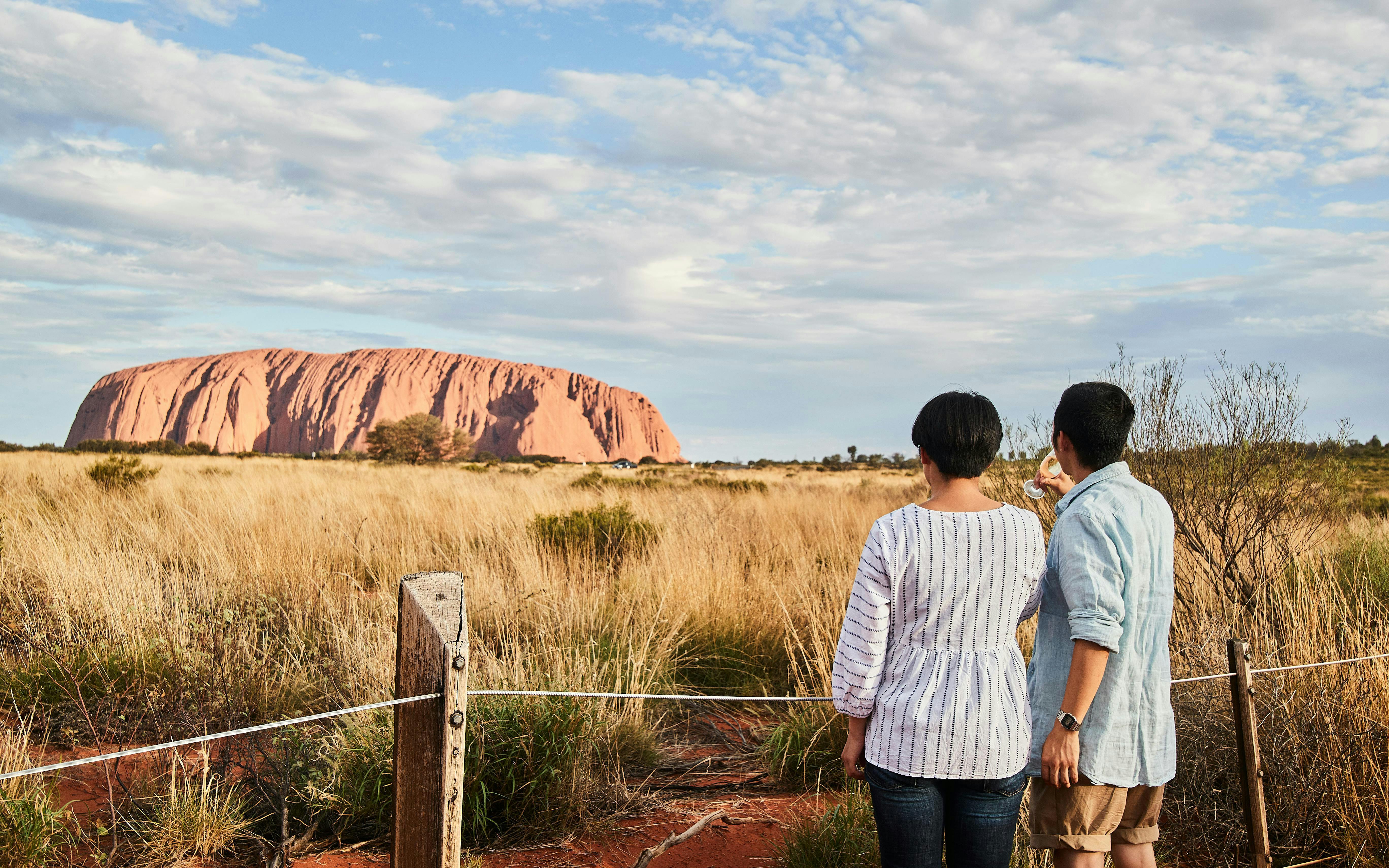 Couple viewing Uluru at sunset during a stargazing tour with BBQ dinner.