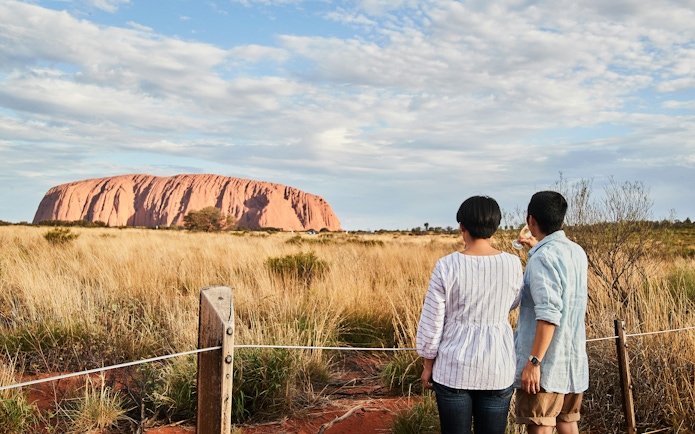 Couple viewing Uluru at sunset during a stargazing tour with BBQ dinner.