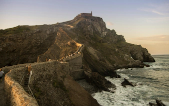 Stone path leading to San Juan de Gaztelugatxe chapel on rocky hill, Spain.