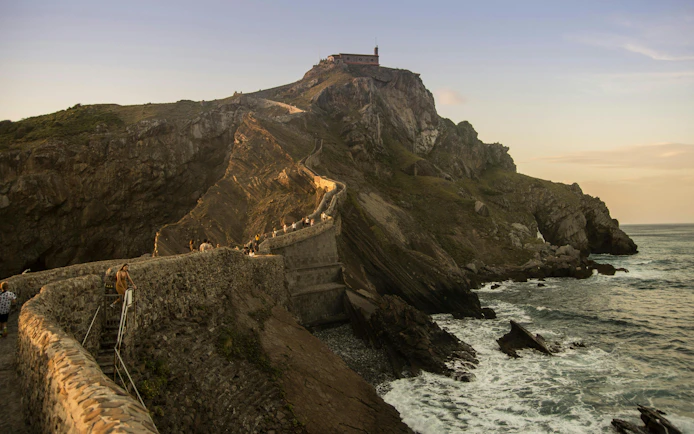 Stone path leading to San Juan de Gaztelugatxe chapel on rocky hill, Spain.