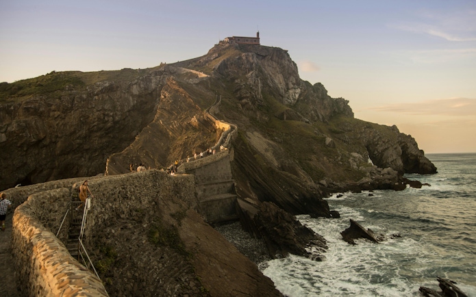 Stone path leading to San Juan de Gaztelugatxe chapel on rocky hill, Spain.