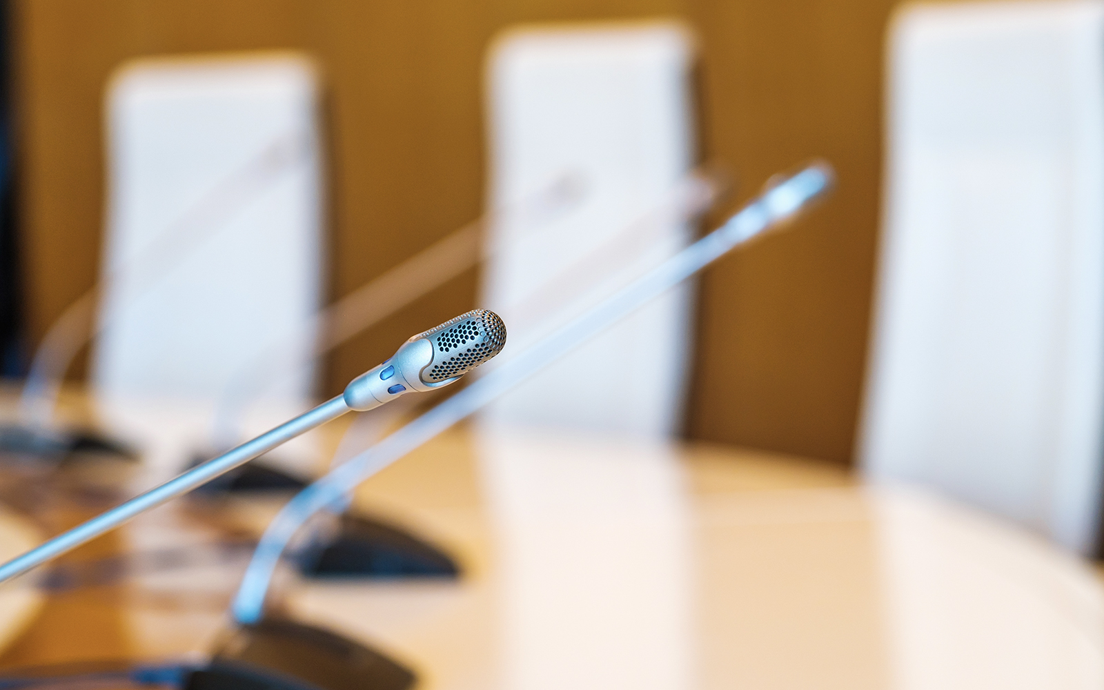 Microphone on conference room table with chairs in background.