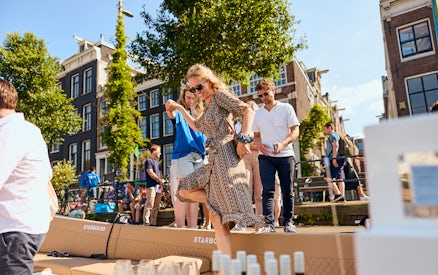 People enjoying a canal cruise in Amsterdam with drinks on board.