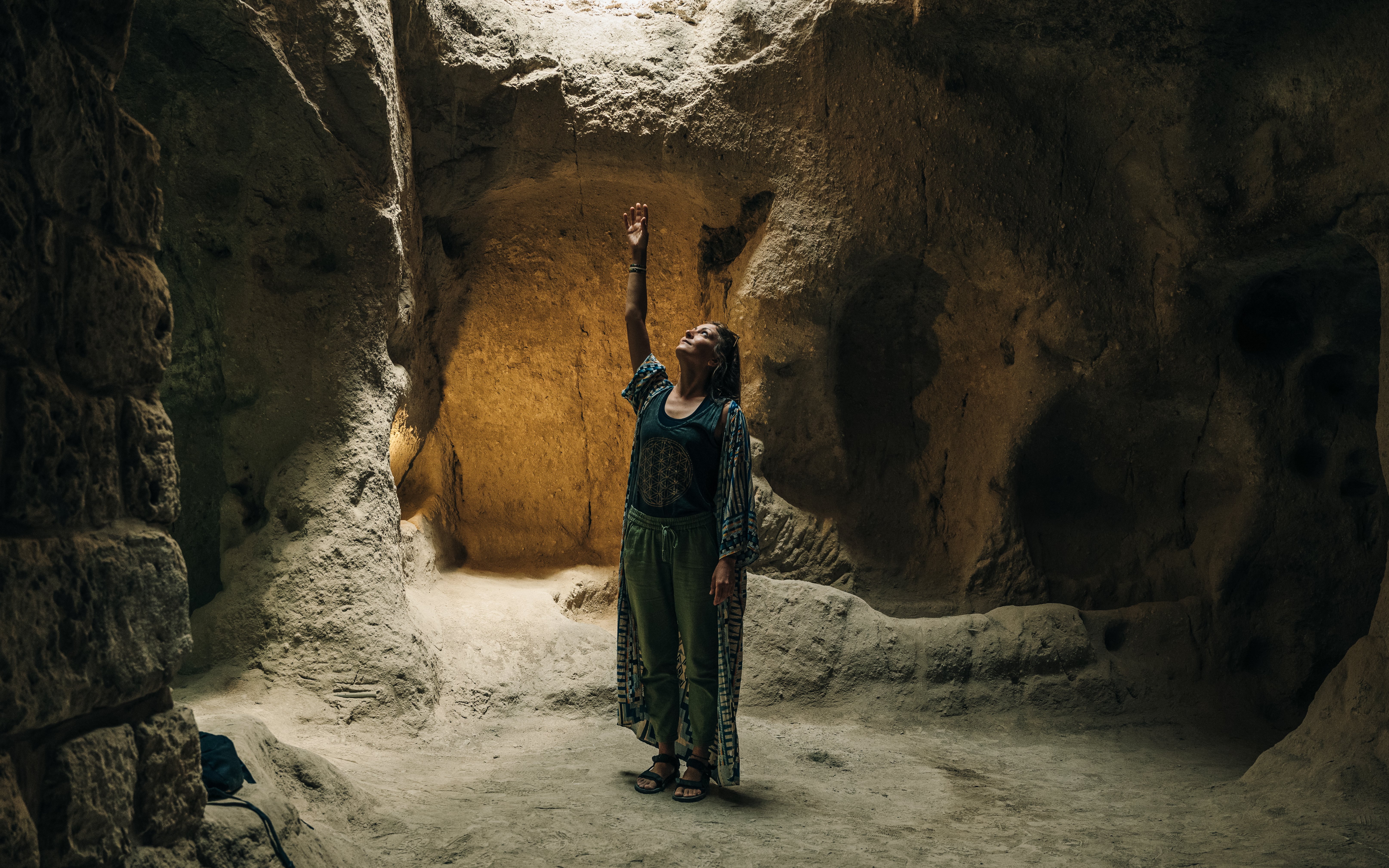 Person exploring an underground chamber in Cappadocia's ancient city.