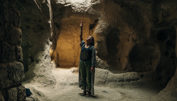 Person exploring an underground chamber in Cappadocia's ancient city.