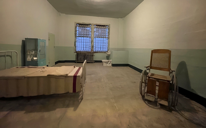 Alcatraz Island prison cell interior with bed and wheelchair.