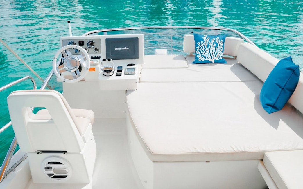 Luxury yacht deck with seating and steering wheel, Dubai.