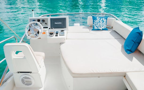 Luxury yacht deck with seating and steering wheel, Dubai.