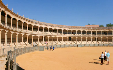 Ronda bullring with tourists on a guided tour in Setenil de las Bodegas, Spain.