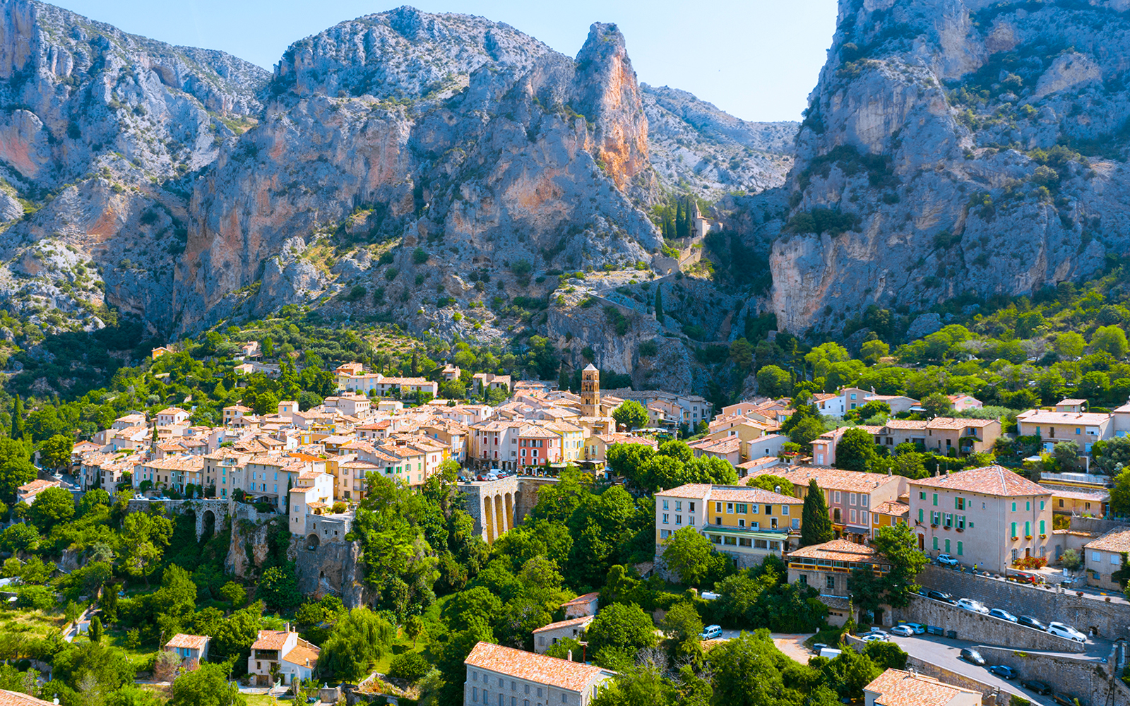Village nestled in the Gorges du Verdon with rocky cliffs and greenery, France.