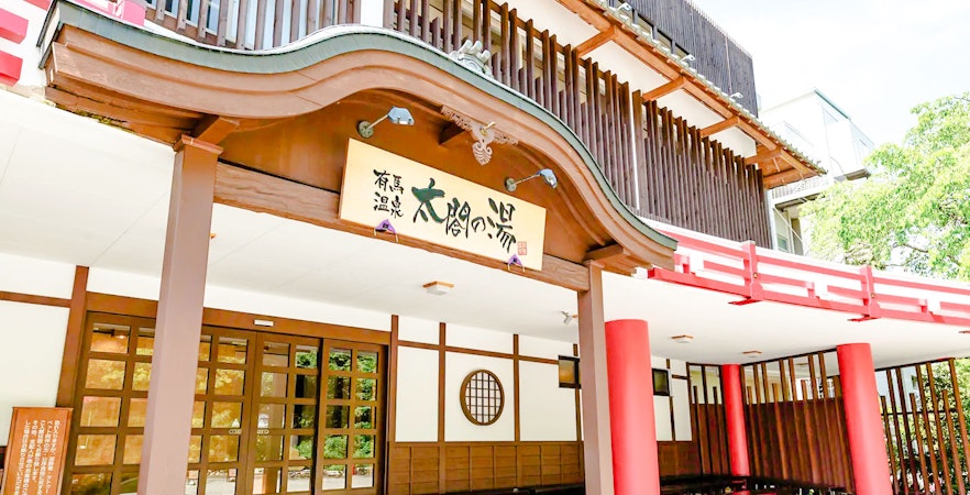 Entrance of Arima Onsen bathhouse in Osaka, featuring traditional Japanese architecture.