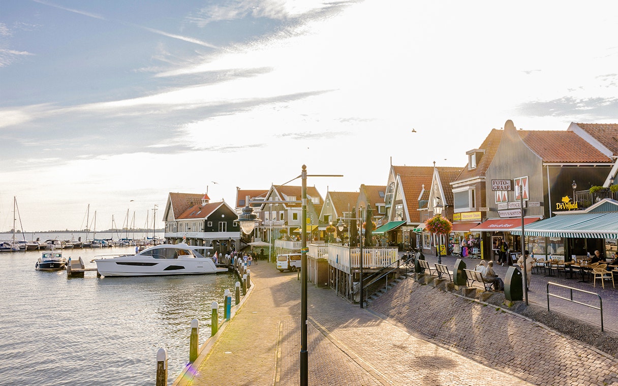 Volendam waterfront with boats docked and traditional Dutch houses.