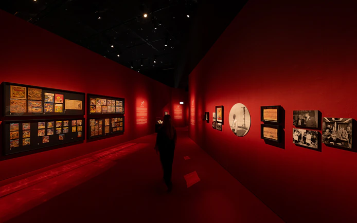 Exhibition hall with red walls displaying art and photographs at ArtScience Museum, Singapore.