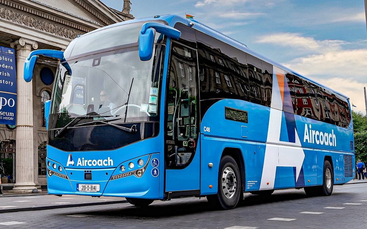 Dublin Aircoach bus for airport transfers in front of a historic building.