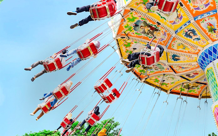 Riders on a colorful swing ride at Dunia Fantasi Dufan Theme Park.
