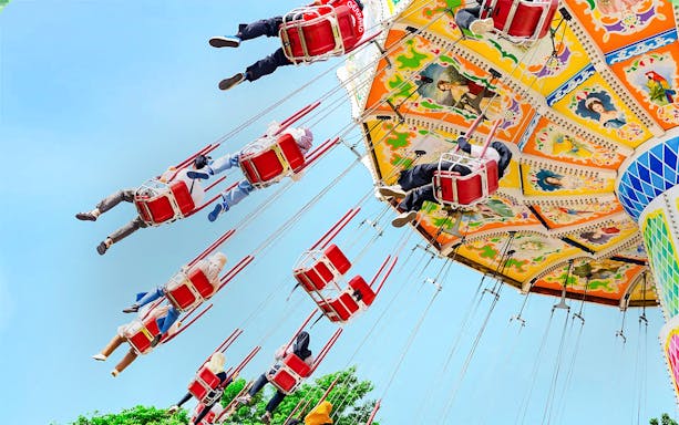 Riders on a colorful swing ride at Dunia Fantasi Dufan Theme Park.