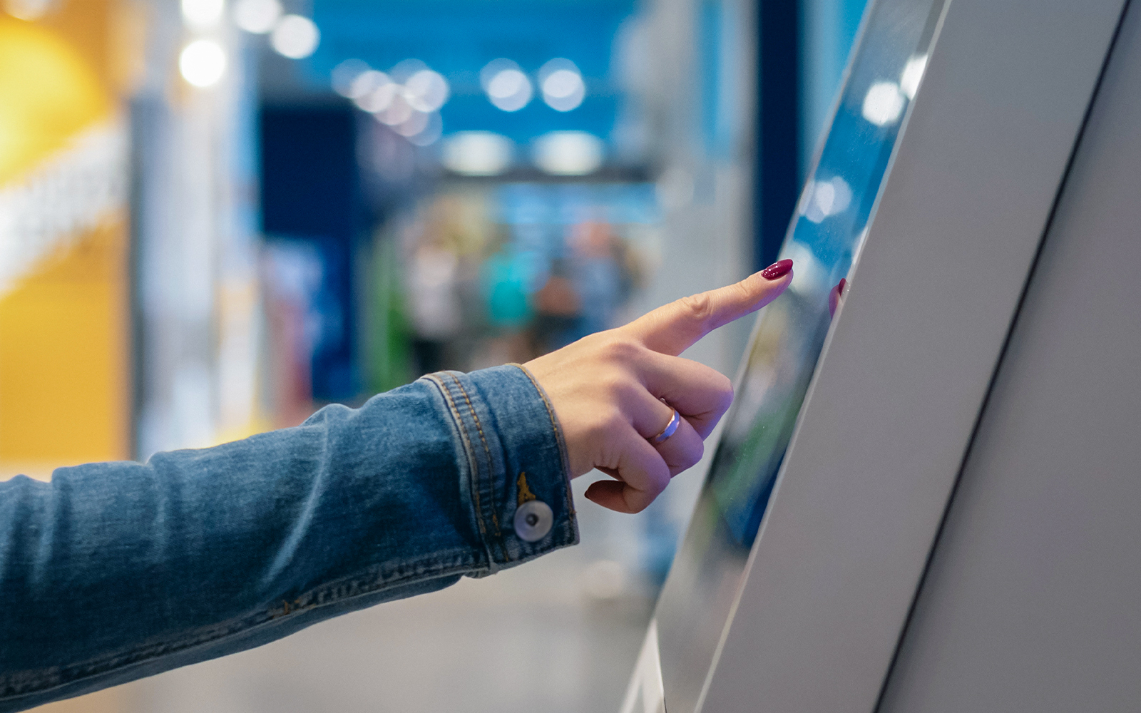 Person interacting with touchscreen in aquarium or museum.